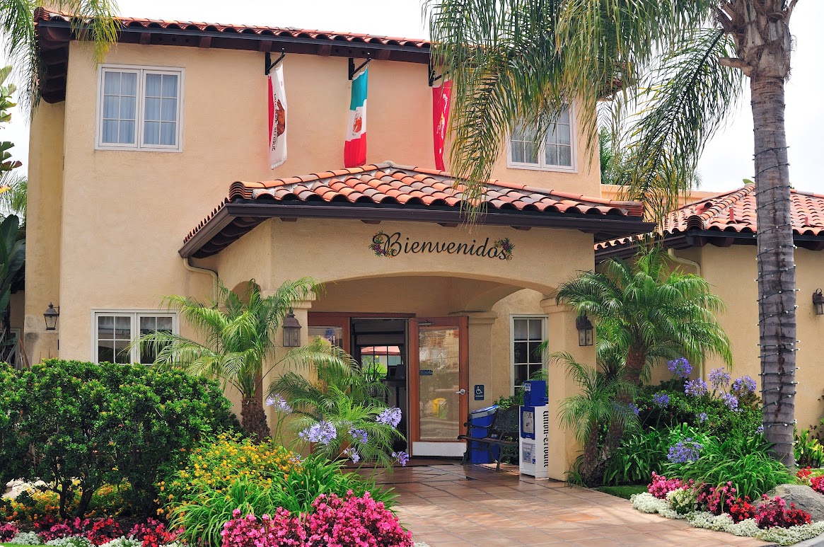 A stucco building with a tiled roof and archway