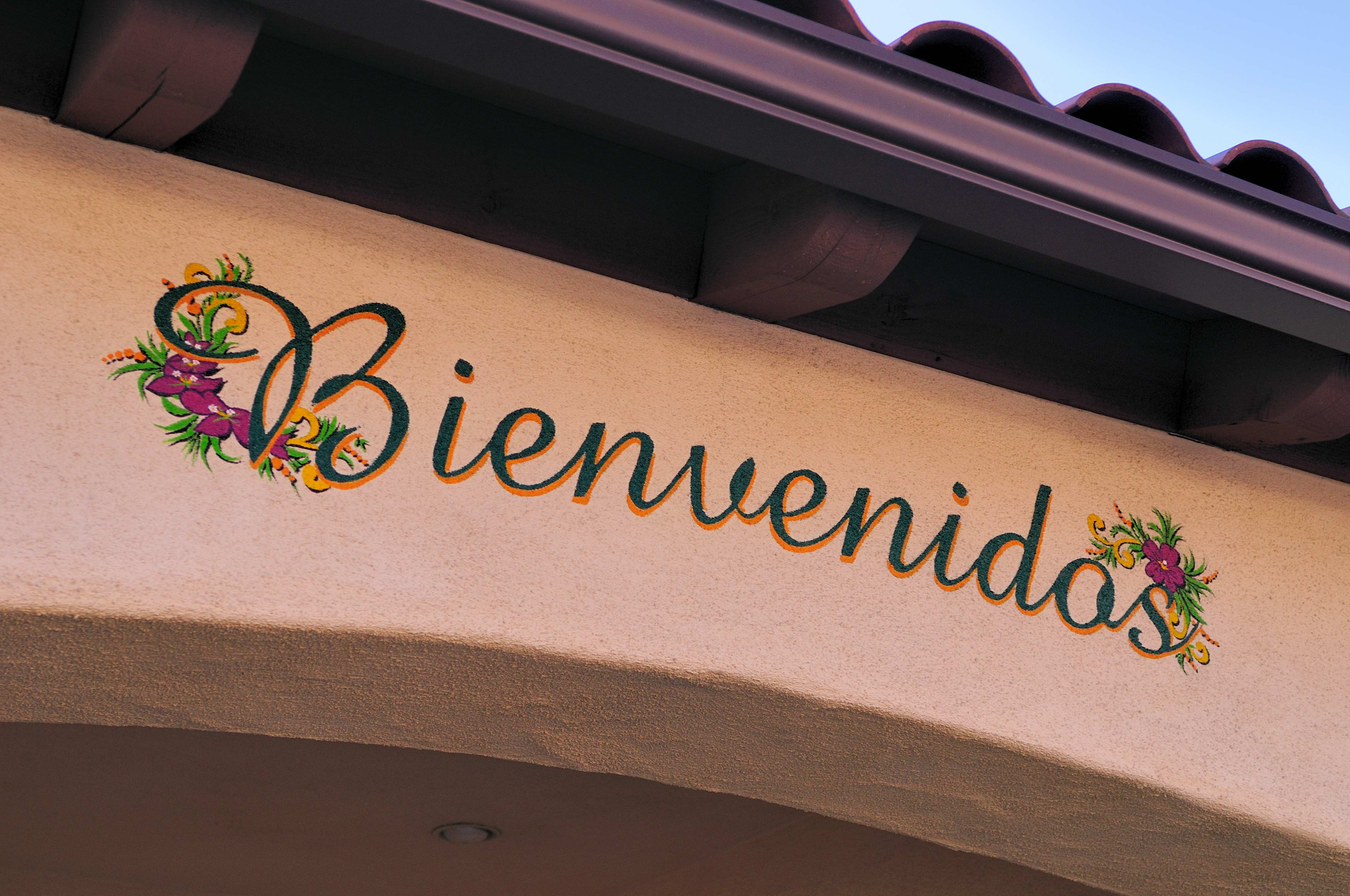 a stucco wall with a sign that says Bienvenidos
