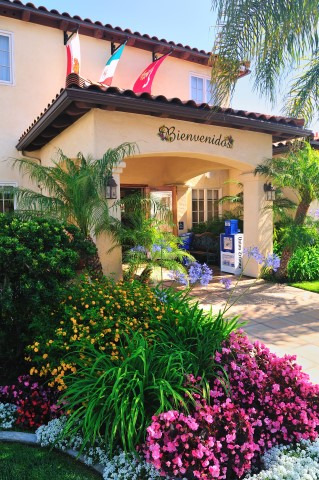 A hotel entrance with a sign that says 'Bienvenida' and flags on the roof