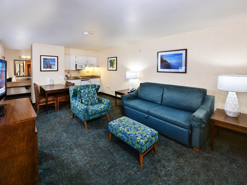 A wide view of a hotel suite with a living room and kitchenette.