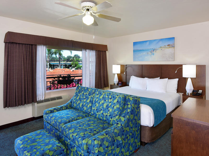 A hotel room with a bed, sofa, and window